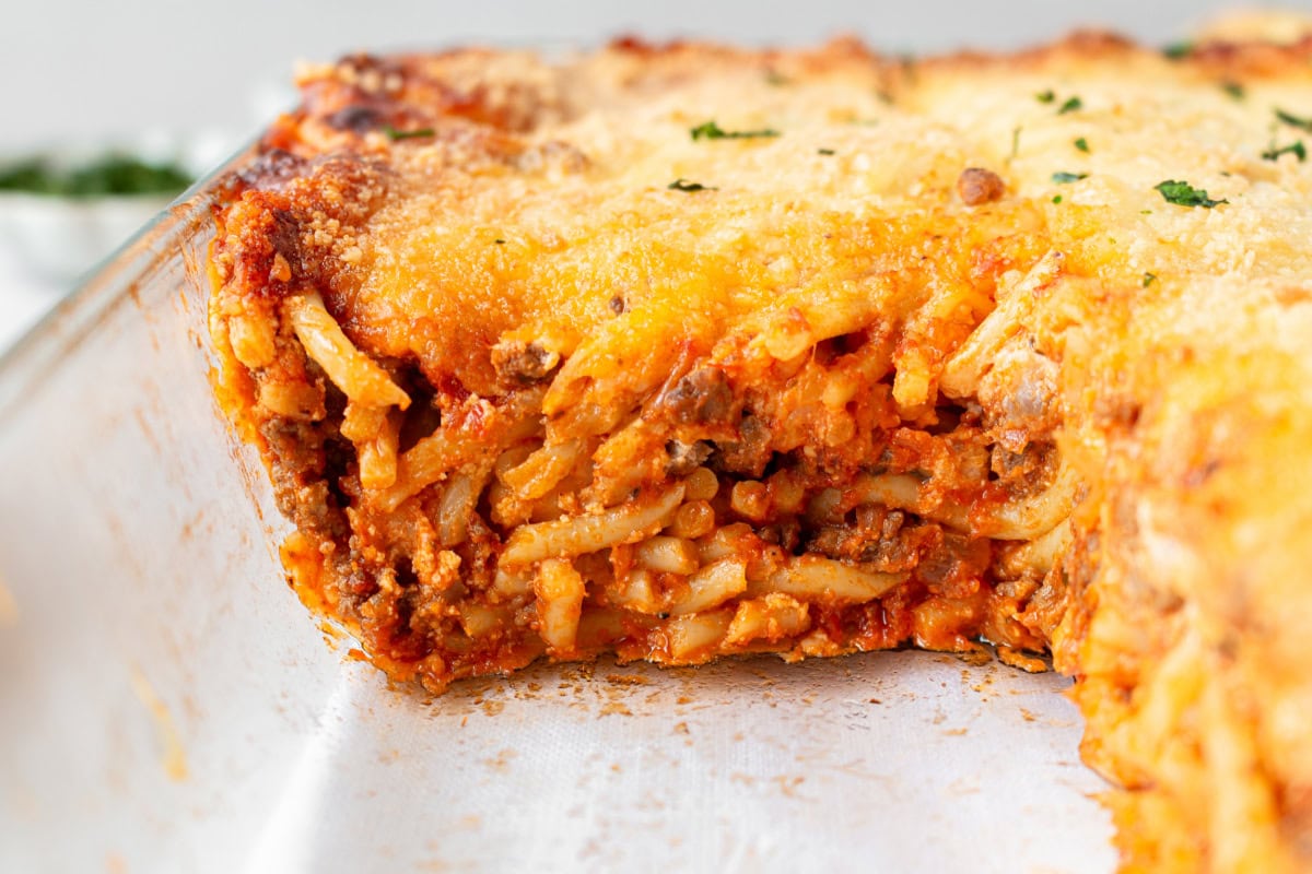 million dollar baked spaghetti in baking dish with slice taken out of it